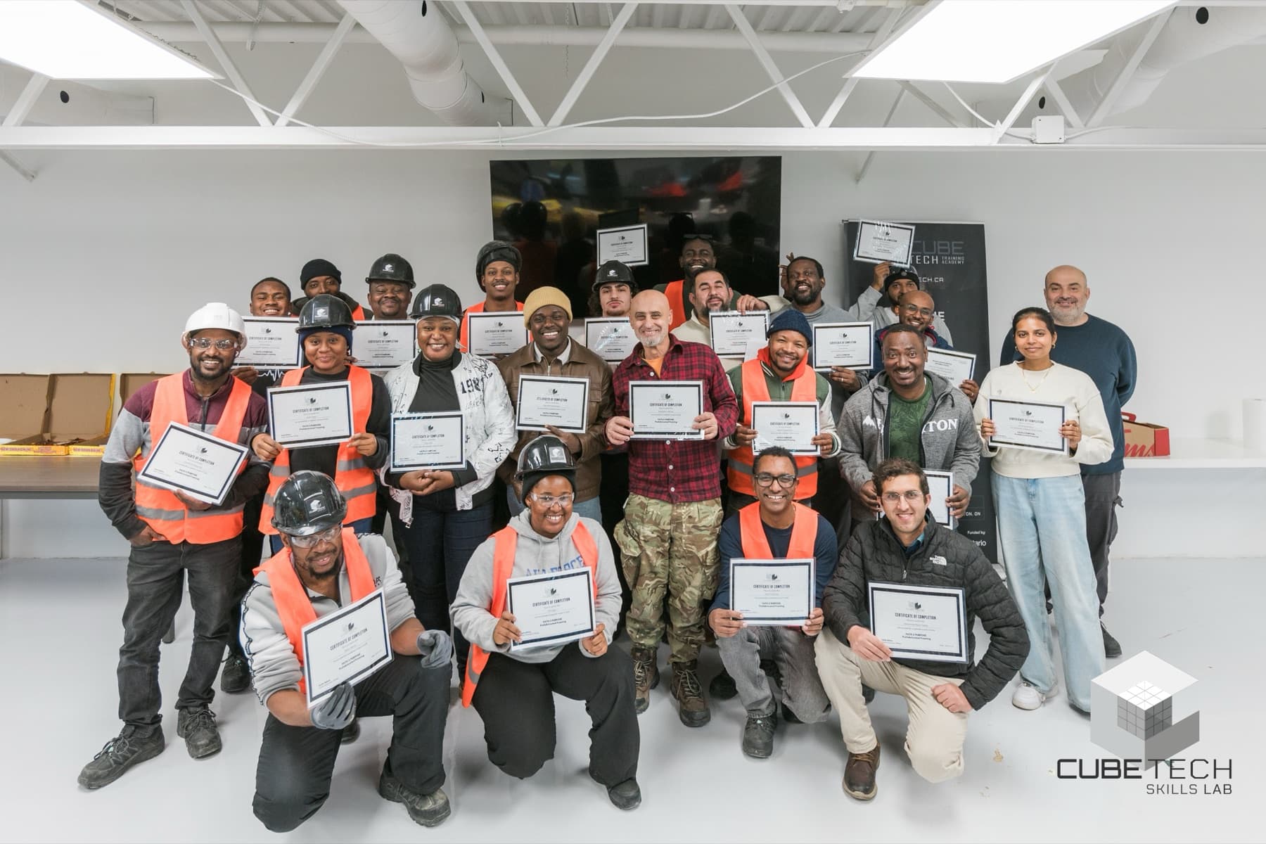 CUBE Tech graduating cohort holding certificates of completion